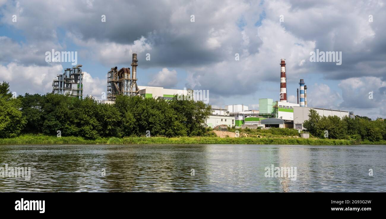 tubi di legno impresa segheria pianta vicino fiume. Concetto di inquinamento dell'aria. Paesaggio industriale inquinamento ambientale spreco di energia termica p Foto Stock
