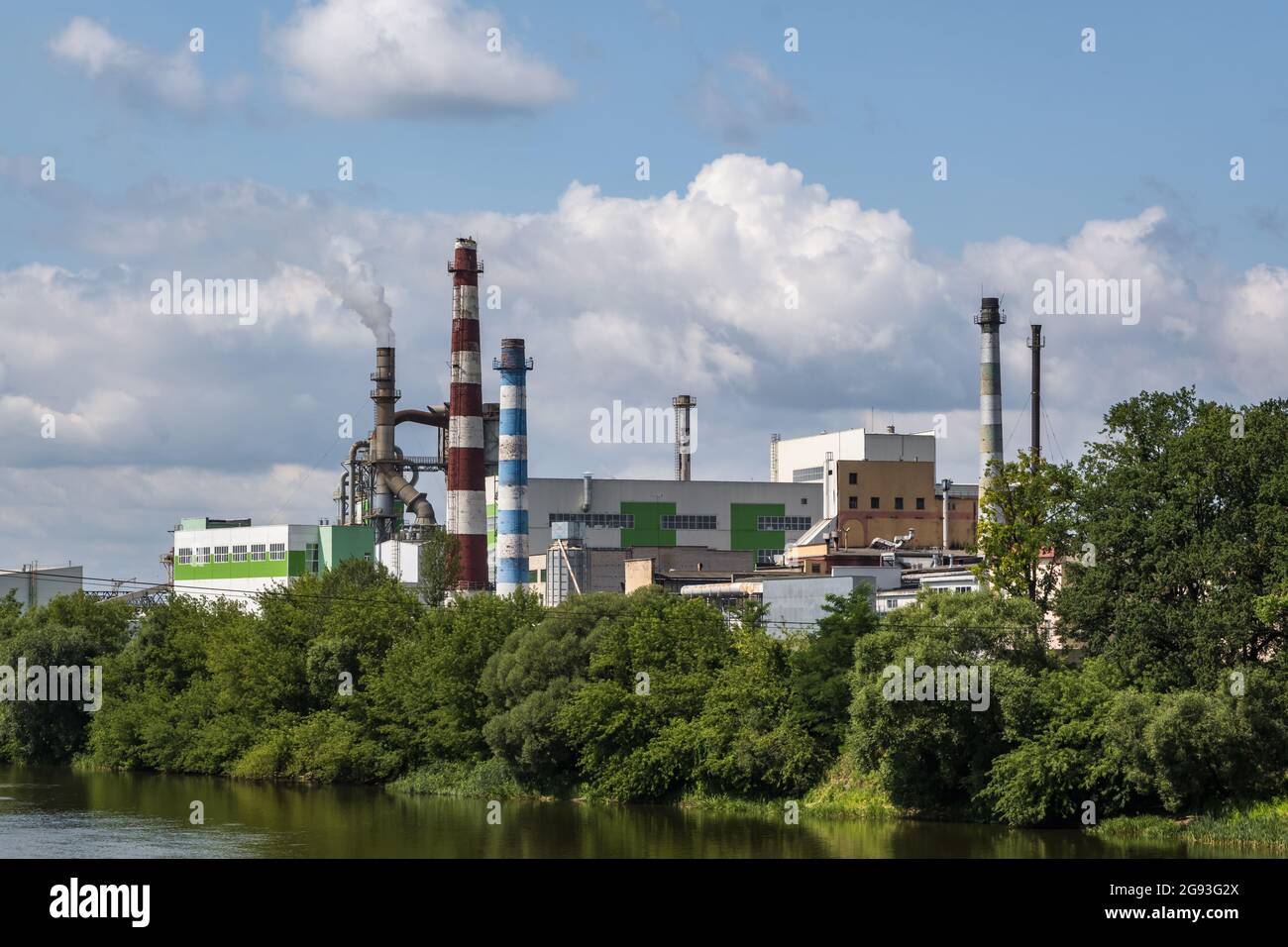 tubi di legno impresa segheria pianta vicino fiume. Concetto di inquinamento dell'aria. Paesaggio industriale inquinamento ambientale spreco di energia termica p Foto Stock