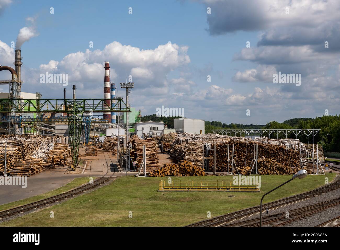 tubi di legno impresa segheria pianta vicino fiume. Concetto di inquinamento dell'aria. Paesaggio industriale inquinamento ambientale spreco di energia termica p Foto Stock