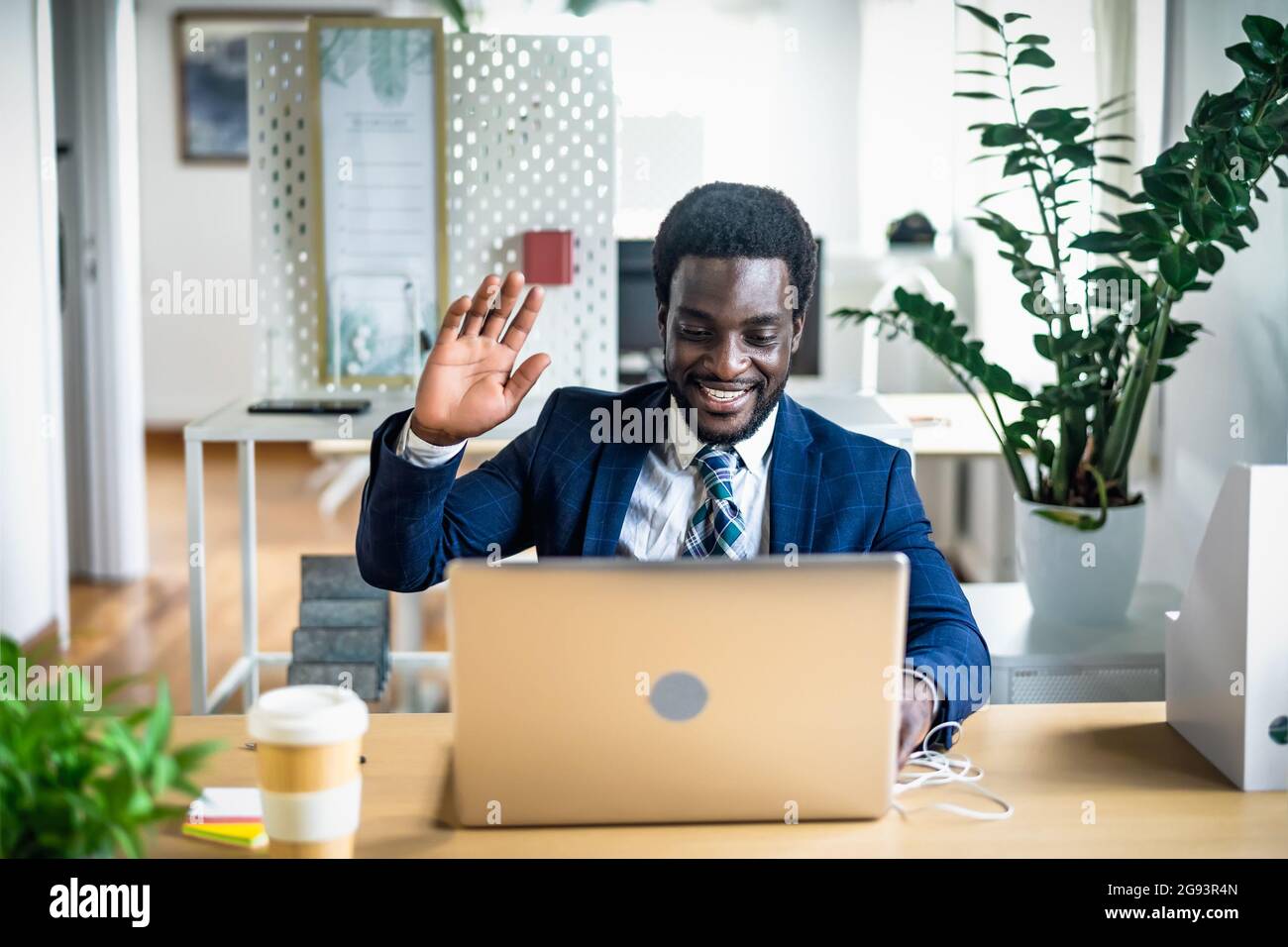 Business Afro uomo che fa una videoconferenza online su un laptop all'interno di un ufficio moderno Foto Stock