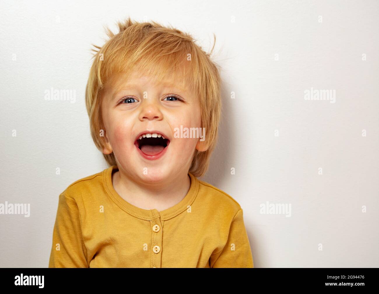 Chiudi felice ritratto biondo piccolo ragazzo ridendo Foto Stock