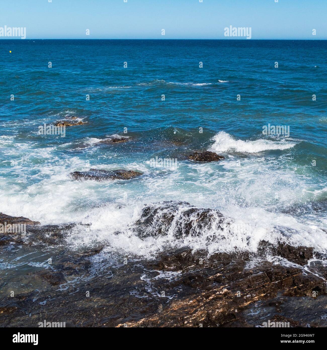 Ondate che si infrangono sulla roccia. Foto Stock