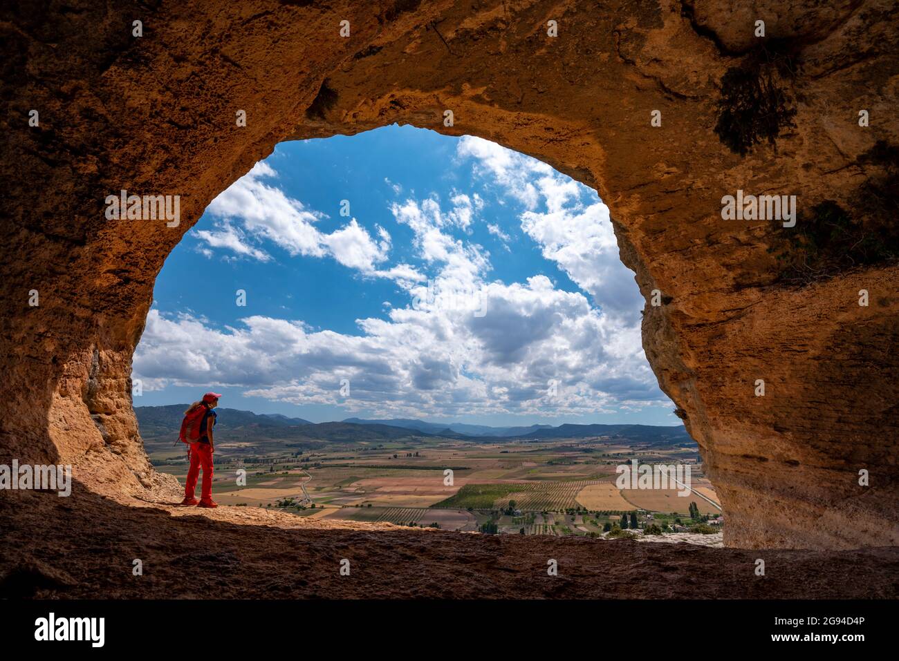 Un'escursione femminile sotto un sentiero panoramico sotto un enorme sporgenza grotte di Zaen, villaggio Zaen, campo de San Juan, Moratalla, Región de Murcia, España Foto Stock