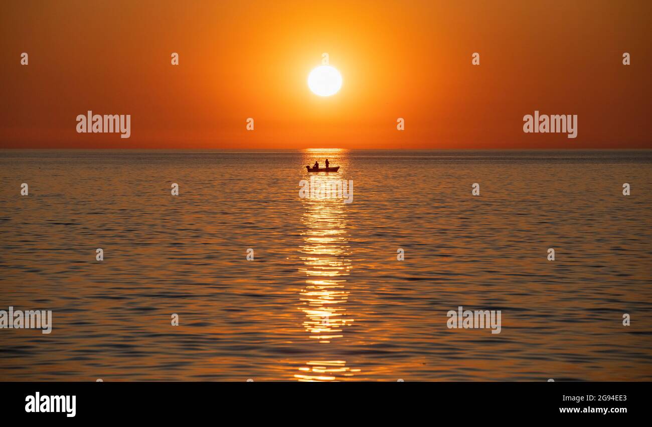 Foto idilliaca della barca da pesca contro il tramonto del sole a Rovigno Foto Stock