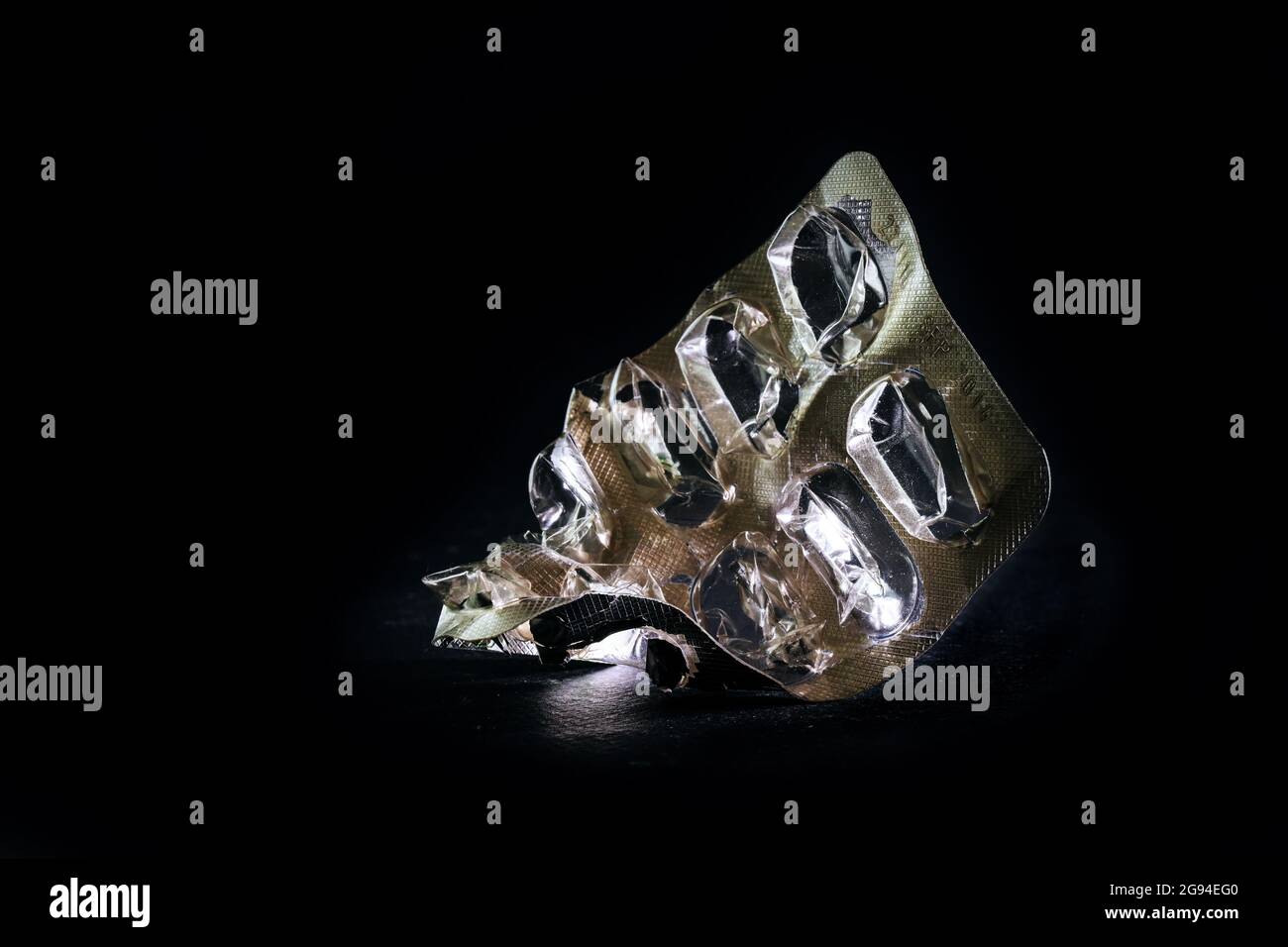 Confezione blister usa e getta per pillole in alluminio e plastica su sfondo nero, concetto per la sanità e la prevenzione dei rifiuti, microplast Foto Stock