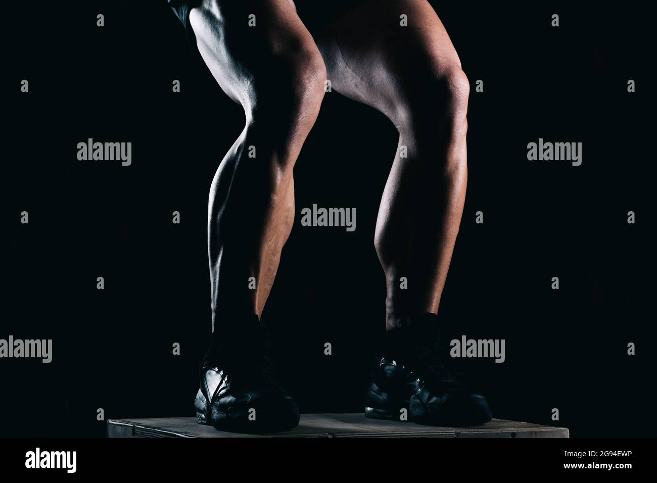 Studio fotografico della parte inferiore delle gambe di un uomo forte con sfondo nero Foto Stock