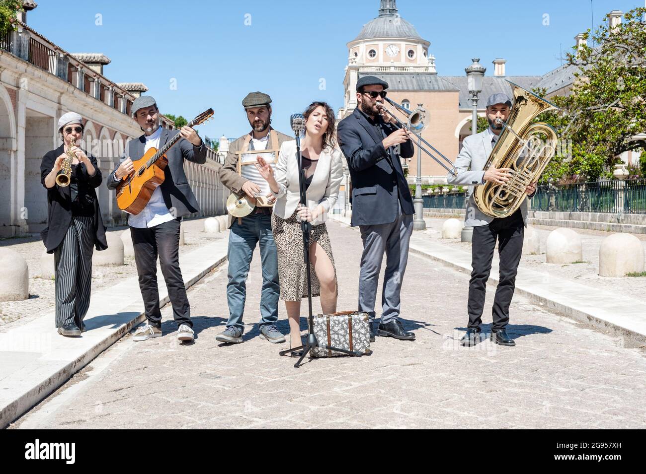Jazz band che suona per strada in piena luce e vestito con giacche, cappelli e abiti; composto da 6 componenti, un cantante, un clarinetto, una tuba, Foto Stock