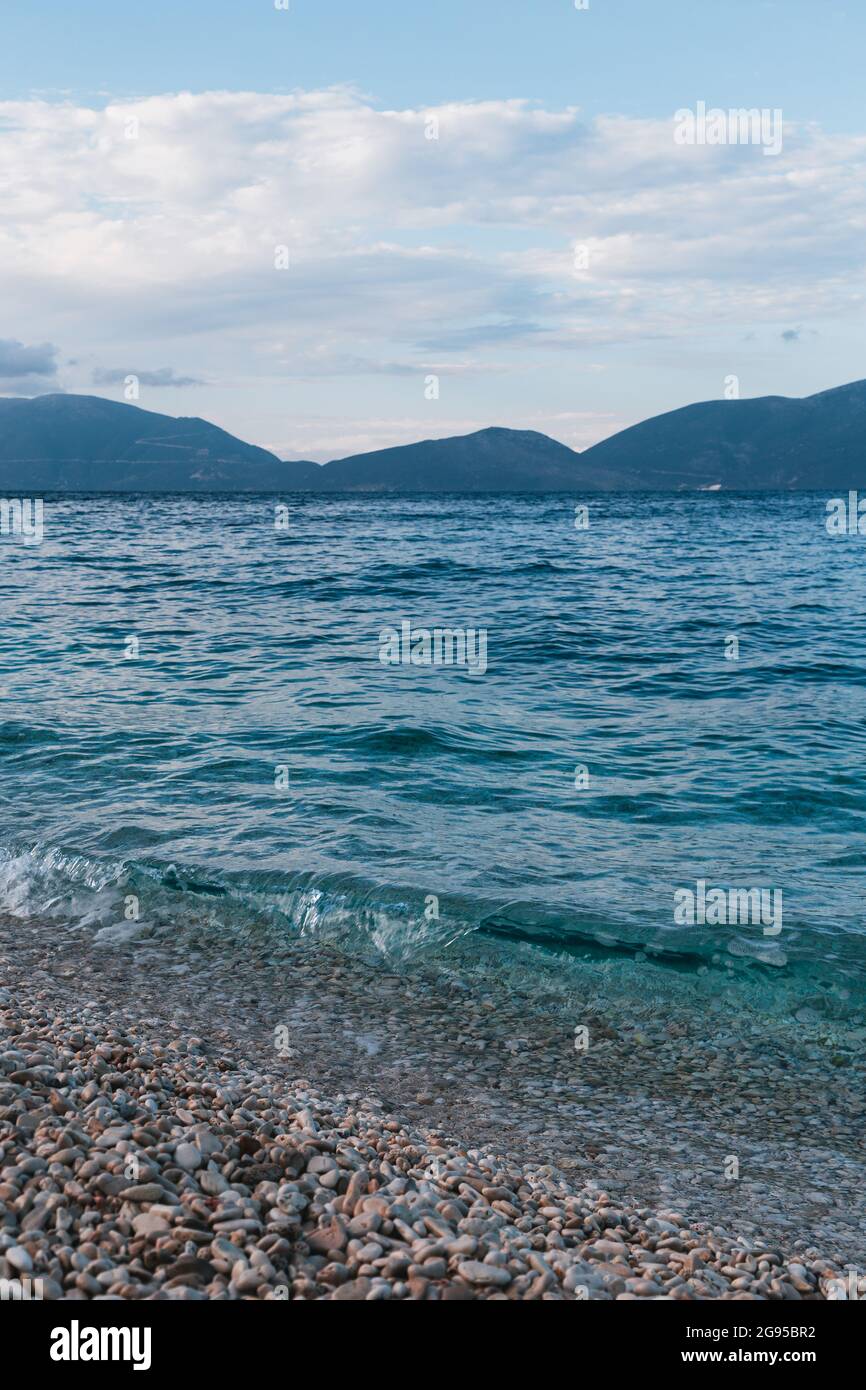 Bella spiaggia greca tempo serale e fantastiche acque azzurre Ionio mare onde. Scenario estivo di Cepha famosa ed estremamente popolare destinazione di viaggio Foto Stock