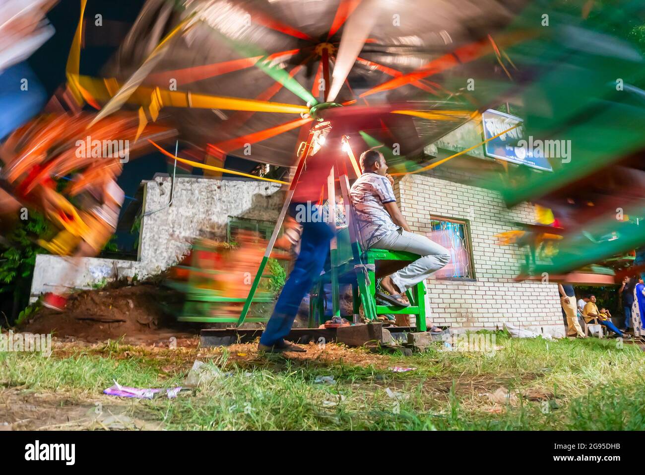Howrah, Bengala Occidentale, India - Aprile 14th 2019 : persona che spinge i bambini a cavallo su Nagordola- un giro di divertimento tradizionale per celebrare il nuovo anno Foto Stock