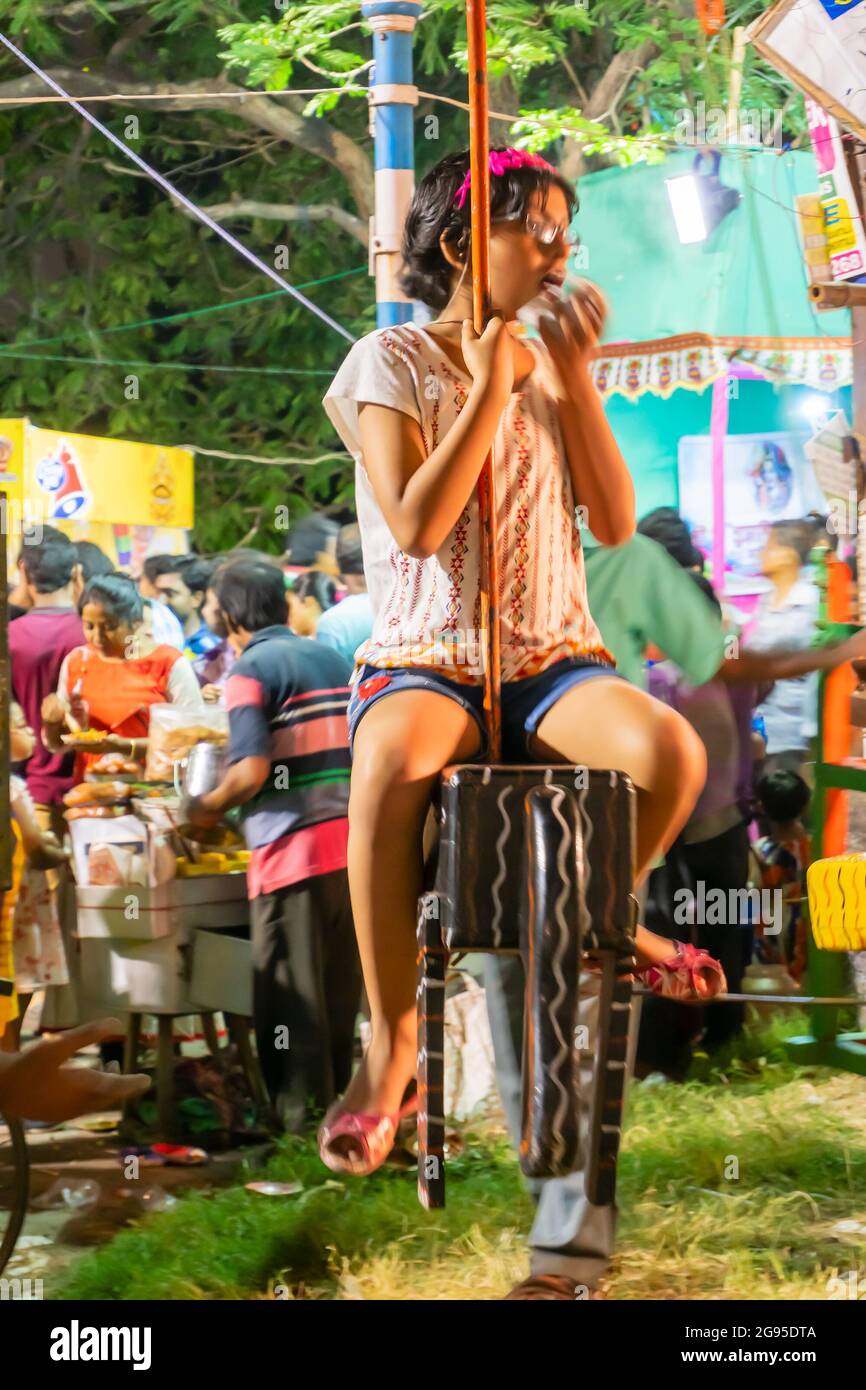 Howrah, Bengala Occidentale, India -14 aprile 2019: Bambina che mangia il fast food a Nagordola, un tradizionale giro di divertimento per festeggiare il primo giorno Foto Stock