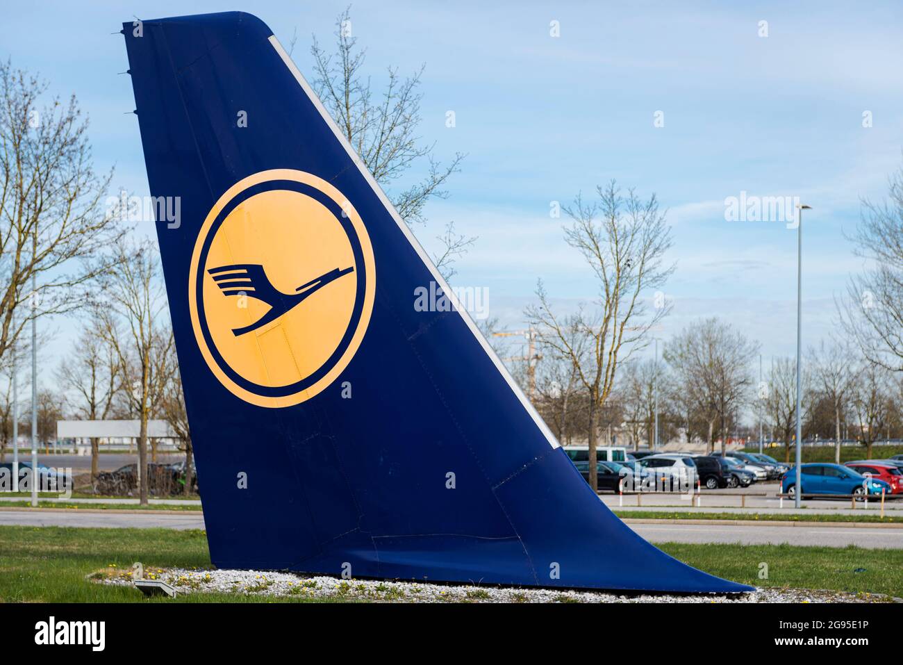 Il logo giallo della gru Lufthansa su una coda verticale blu decommissionata di un aeromobile posto a terra all'aeroporto di Monaco. Foto Stock
