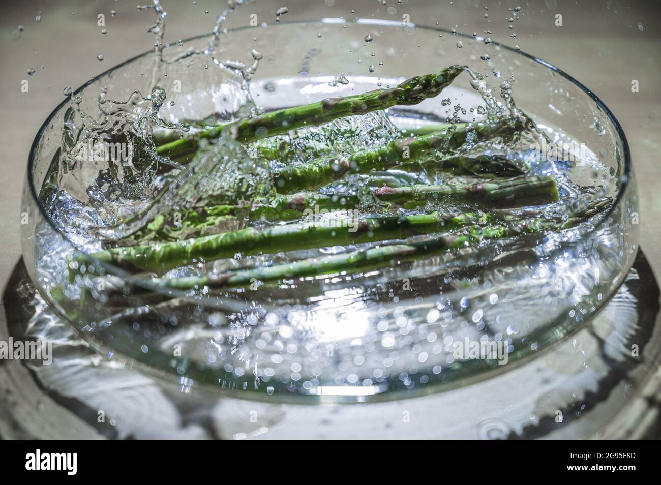 Asparagi vegetali freschi e sani in una ciotola di gocce d'acqua. Verde comprato al mercato del coltivatore. Cibo ad alto contenuto di vitamine. Foto Stock