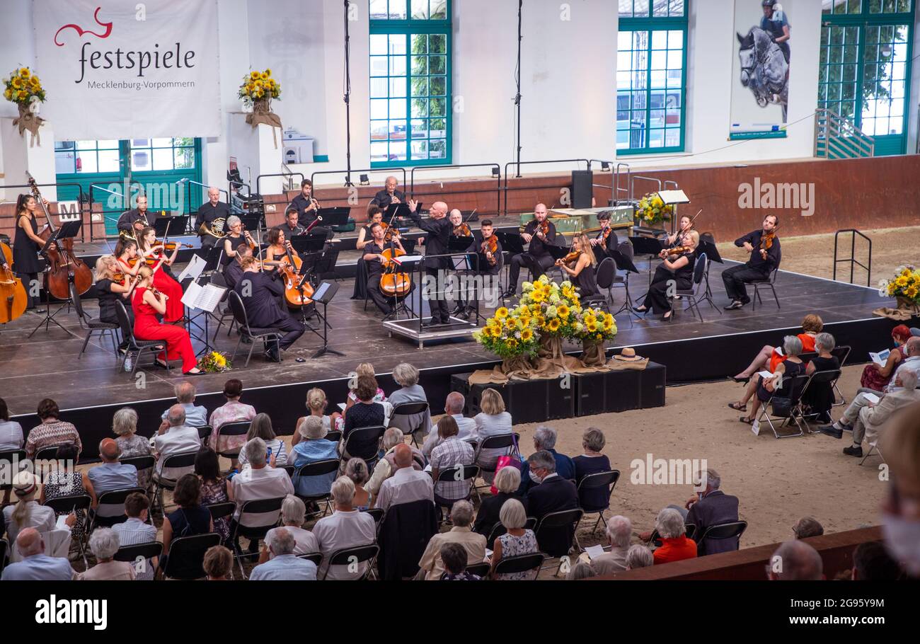 Redefin, Germania. 24 luglio 2021. La star del violino Daniel Hope e l'Orchestra da camera di Zurigo sotto Christoph Eschenbach suoneranno di nuovo i concerti del festival presso la fattoria statale dopo la pausa forzata dell'anno scorso a causa della corona. Questo fine settimana si terranno quattro concerti in totale nella sala di equitazione del prigioniero classico. Sono ammessi al massimo 1250 ascoltatori. Prima del concerto, c'era il tradizionale picnic all'aperto e uno spettacolo di cavalli da guardare. Credit: Jens Büttner/dpa-Zentralbild/dpa/Alamy Live News Foto Stock