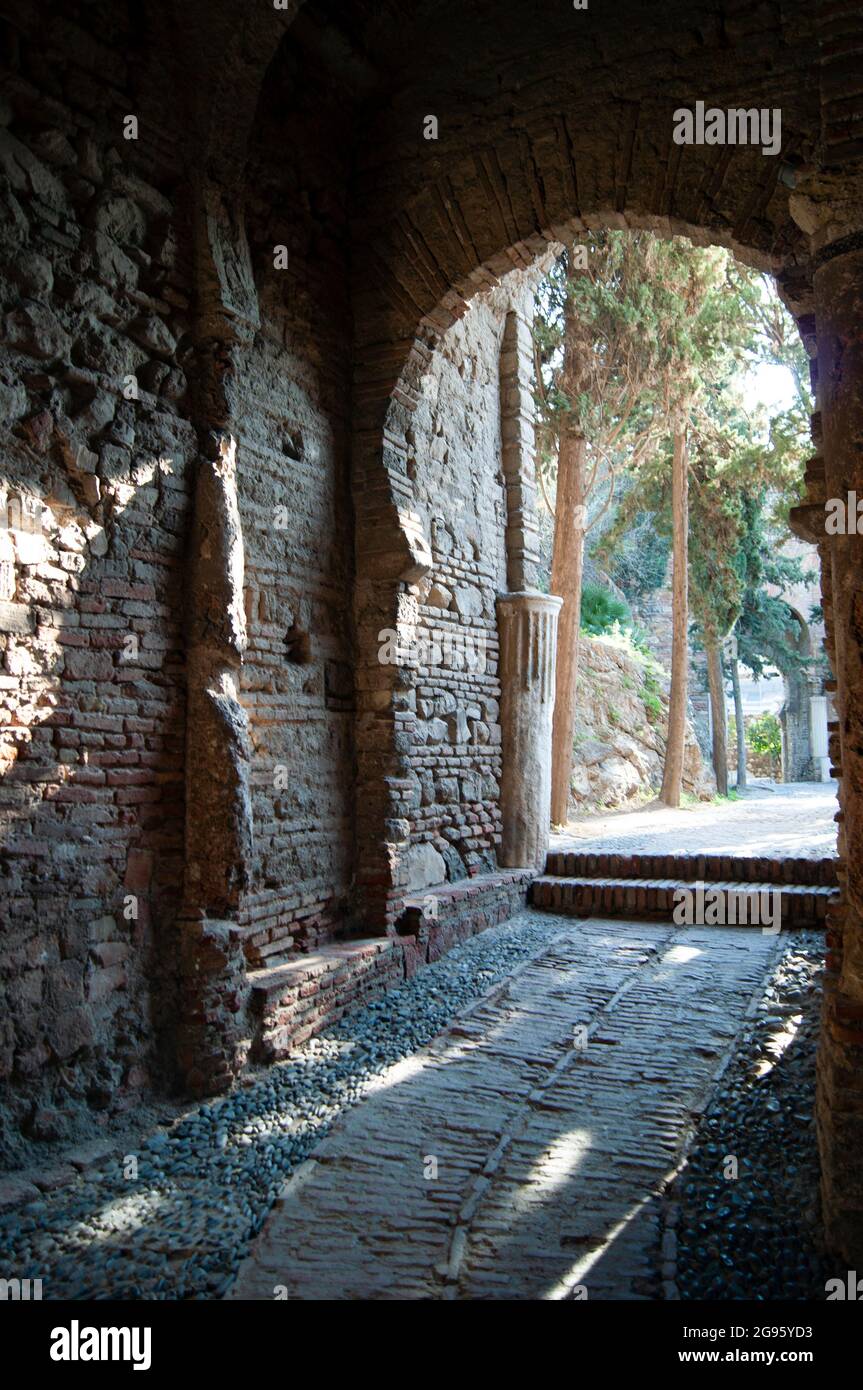 Spagna - Malaga, il monumento moresco di Alcazaba. Una porta ad arco su un percorso acciottolato. Foto Stock