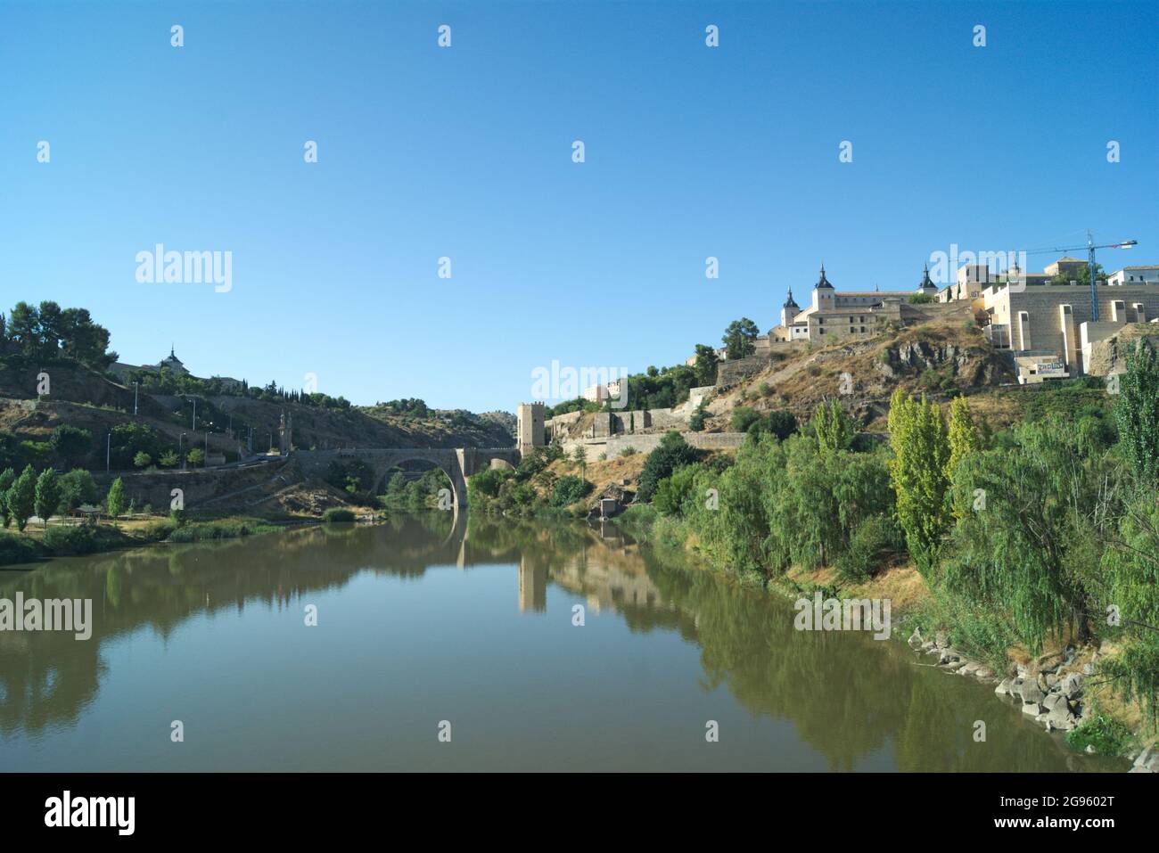 Spagna, Toledo, il bellissimo ponte storico di Alcantara. Il monumento si riflette nelle acque ferme del fiume Tago. Foto Stock