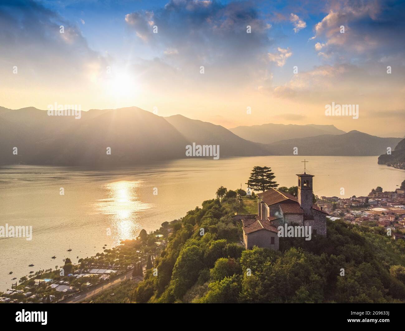 Bellissima vista panoramica aerea dal drone al lago d'Iseo con chiesa in cima alla collina, Lombardia, Italia Foto Stock
