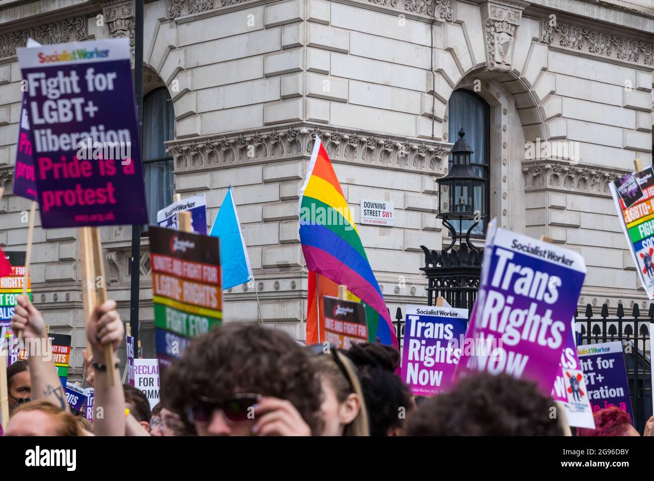 Bandiera arcobaleno e cartelloni con il segno di Downing Street sullo sfondo, durante la protesta di orgoglio reclamata, Londra, organizzata da Peter Tatchell Foto Stock