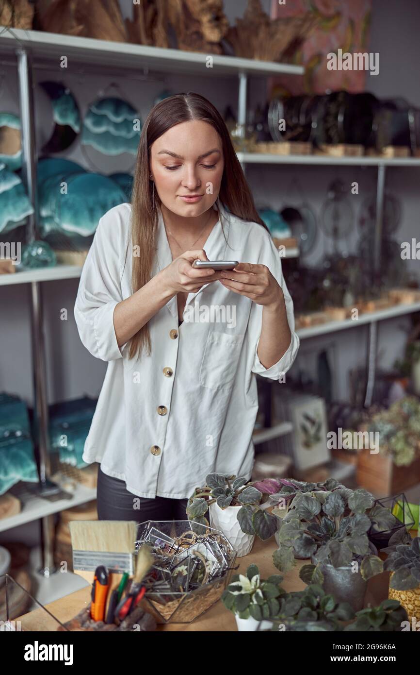 Giovane caucasica felice donna venditore al negozio botanico Foto Stock