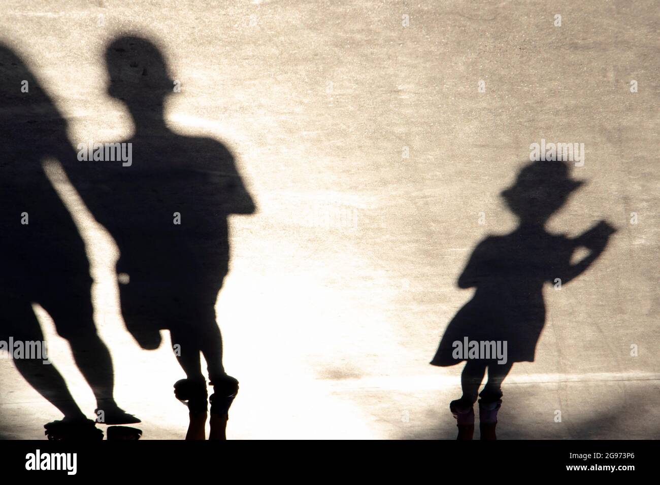 La silhouette oscurare di un bambino che cammina su una passeggiata in una giornata estiva Foto Stock