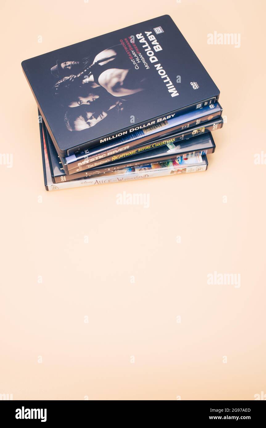 COMO, ITALIA - 18 luglio 2021: Una pila di DVD e blu-ray italiani isolati su sfondo marrone chiaro con spazio di copia Foto Stock