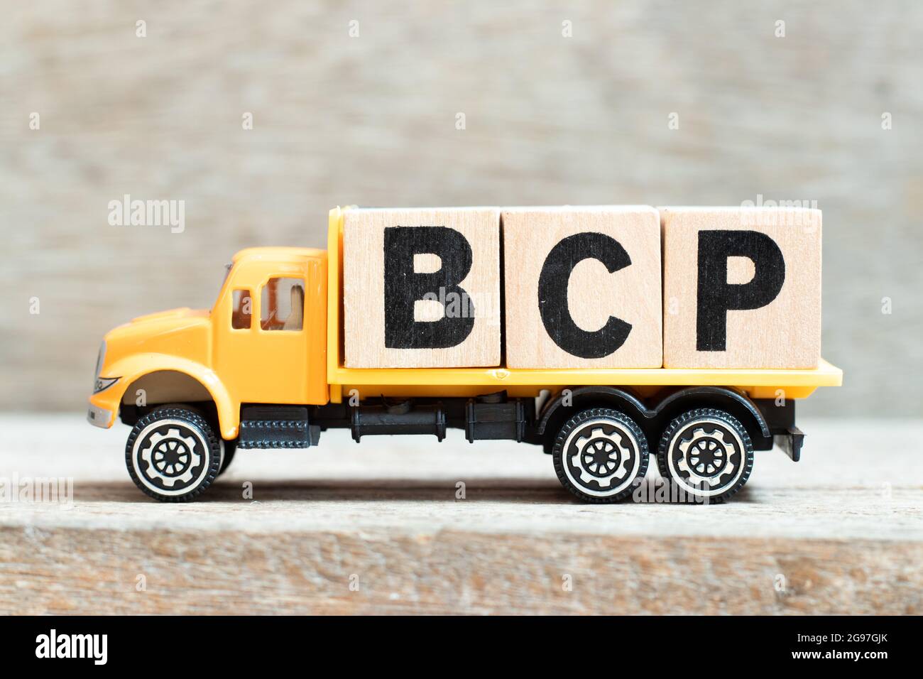 Carrello giocattolo tenere alfabeto blocco di lettere in parola BCP (abbreviazione business continuity plan) su sfondo di legno Foto Stock