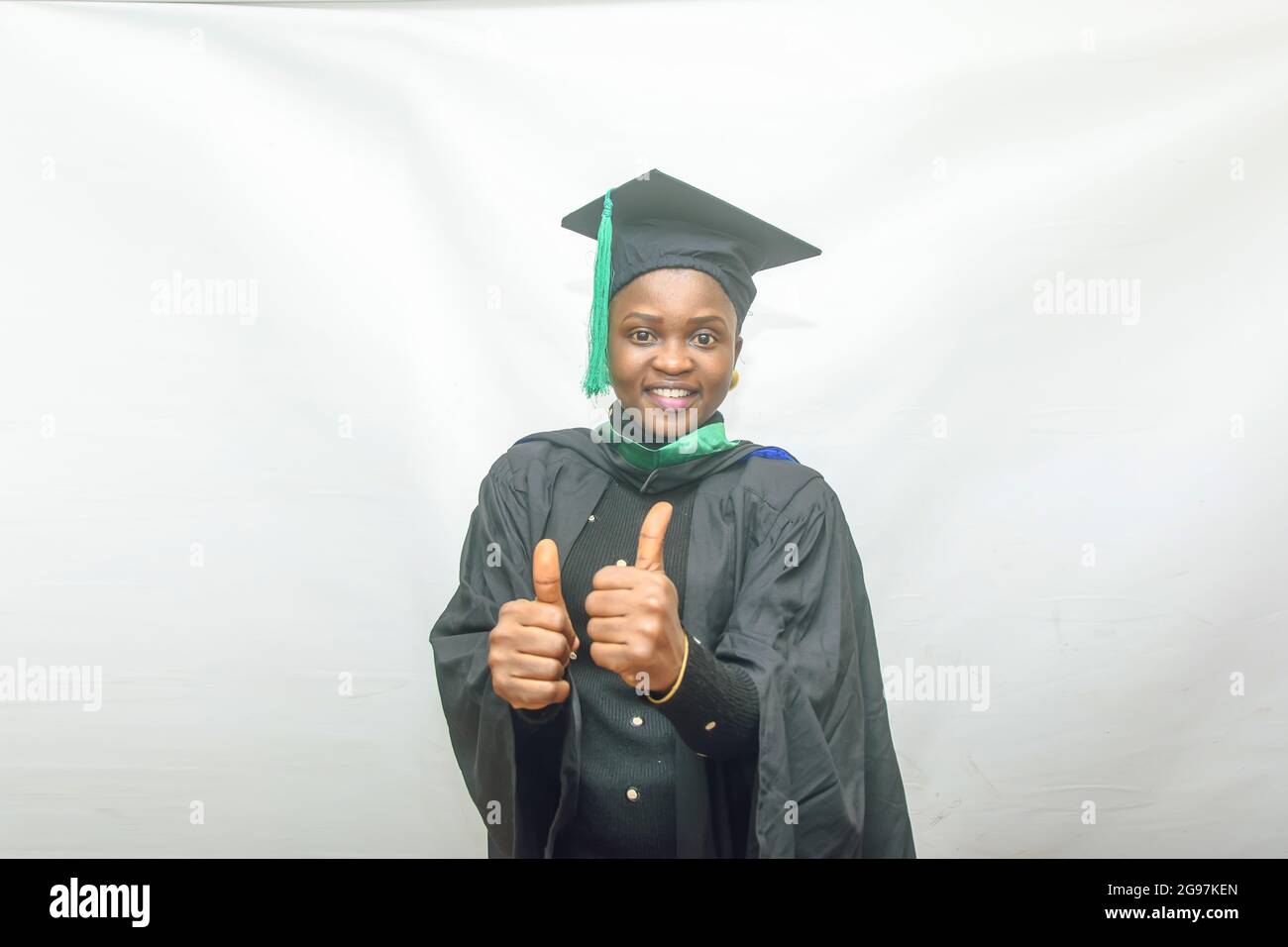 Foto di borsa di una donna africana laureata e/o laureata studenti nel suo vestito  nero di laurea e gioiosamente facendo i pollici verso l'alto gesto Foto  stock - Alamy