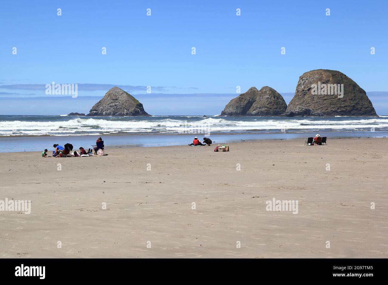 EDITORIALE- Oceanside Beach, Oregon 29/05/2021: Vista delle persone sulla spiaggia di Oceanside, con le tre rocce arco sullo sfondo. Foto Stock