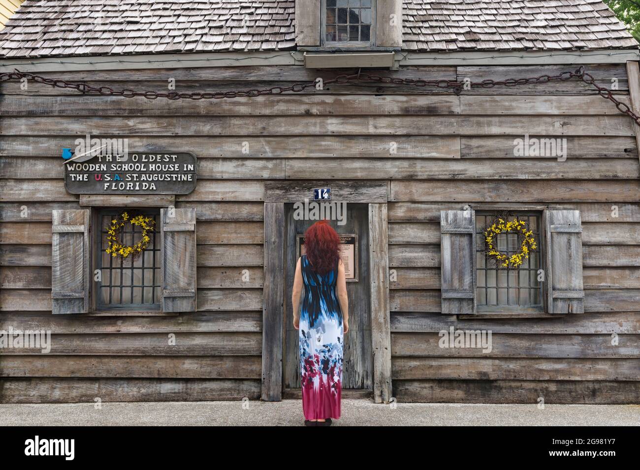 Donna che guarda la più antica Casa della Scuola di legno negli Stati Uniti, Saint Augustine, Florida, Stati Uniti Foto Stock