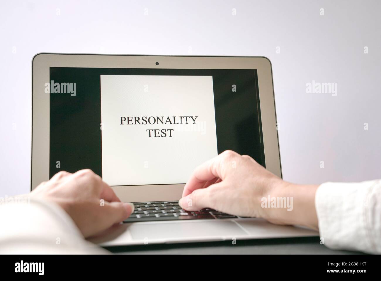 Donna mano sul computer portatile con la parola test di personalità sullo schermo. Concetto di colloquio di lavoro o di carriera. Foto Stock