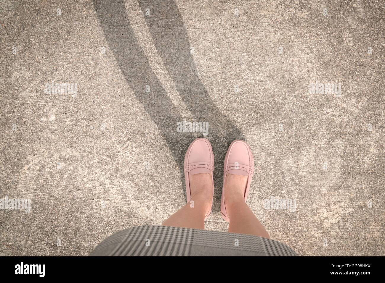 Vista dall'alto della donna che indossa scarpe rosa con ombra sulla strada. Spazio di copia. Foto Stock