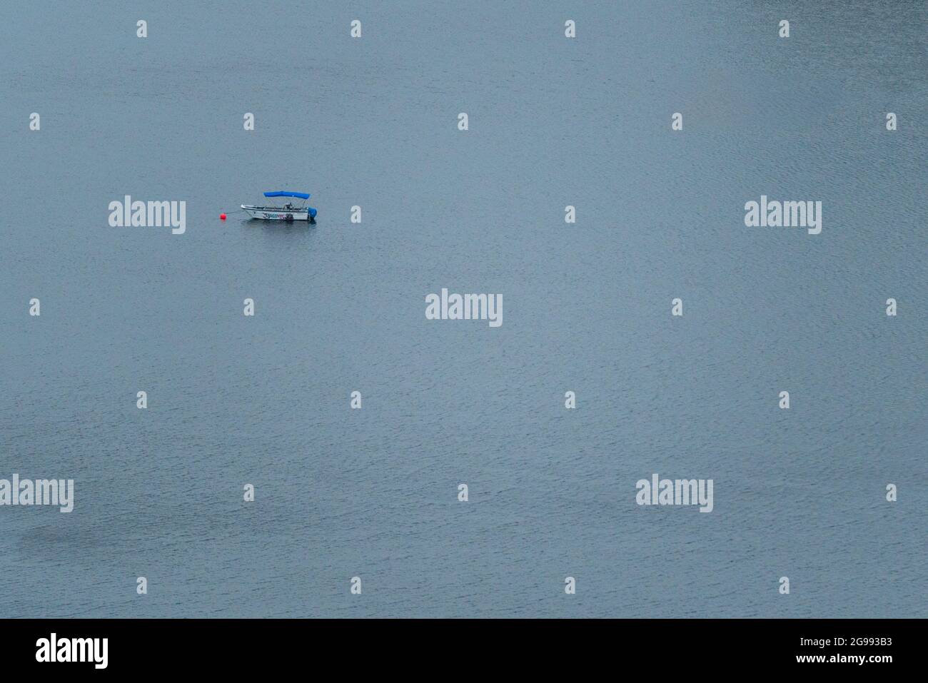 una piccola barca in un corpo d'acqua senza persone Foto Stock