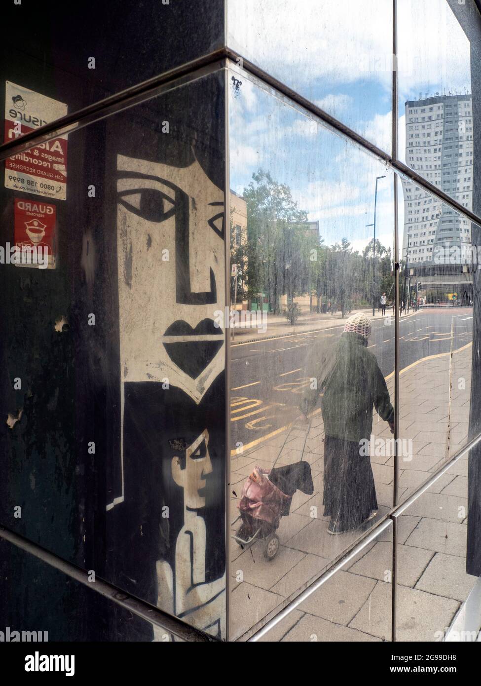 Riflessione di vecchia Signora con shopping Trolly, Newcastle upon Tyne, Tyneside, Foto Stock