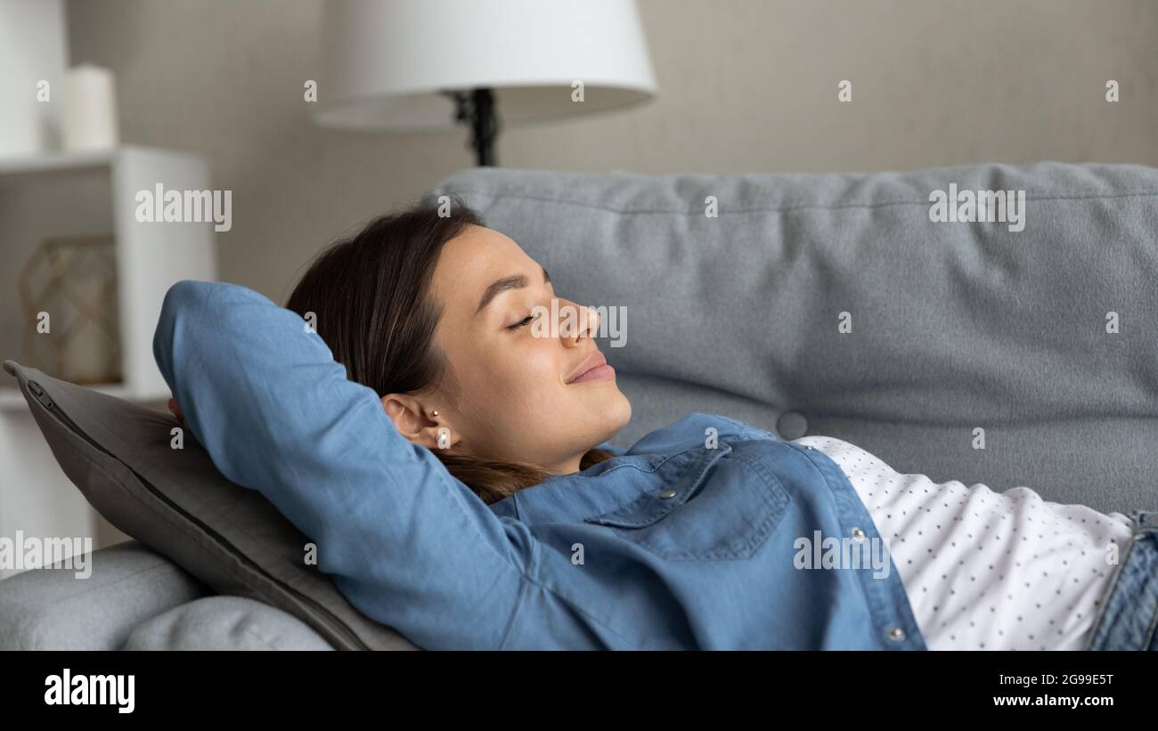 Primo piano bella giovane donna che si rilassa sul divano Foto Stock
