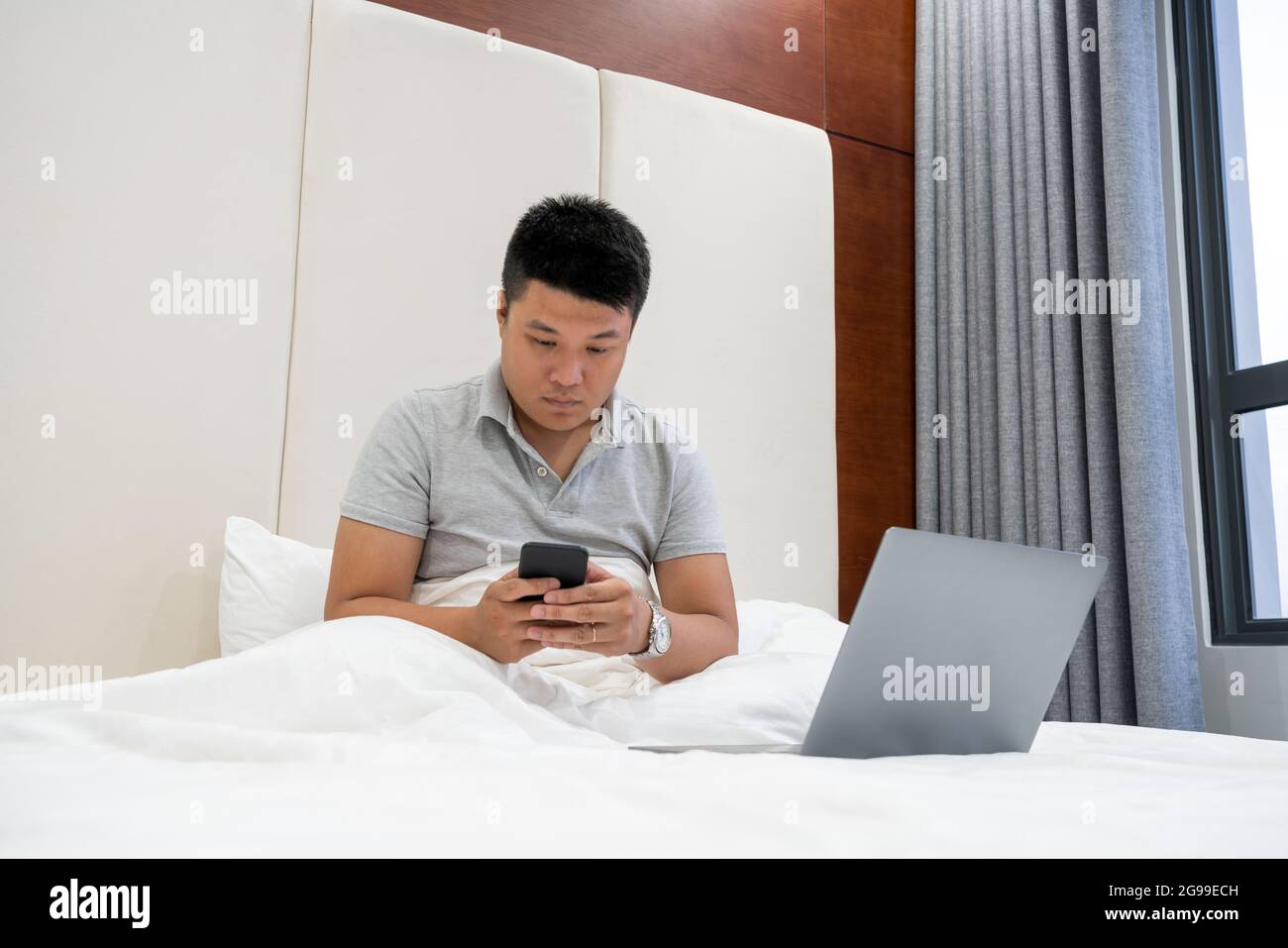 Controllare le e-mail sullo smartphone nella camera d'albergo Foto Stock
