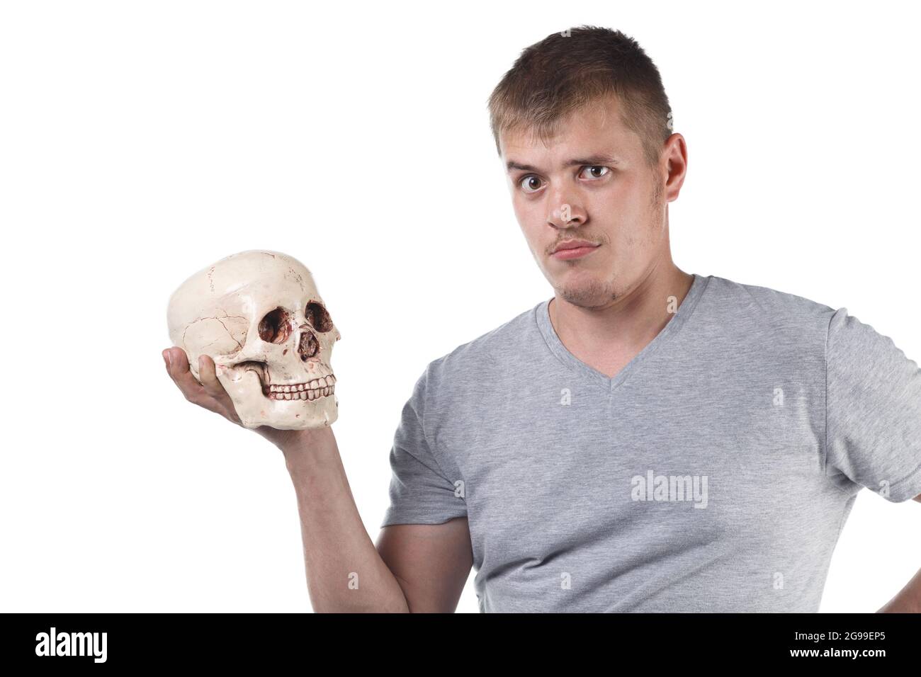 Foto di un uomo perplesso che tiene il cranio umano Foto Stock
