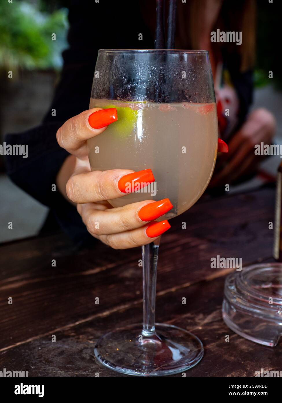 Unghie rosse e un cocktail. Foto Stock