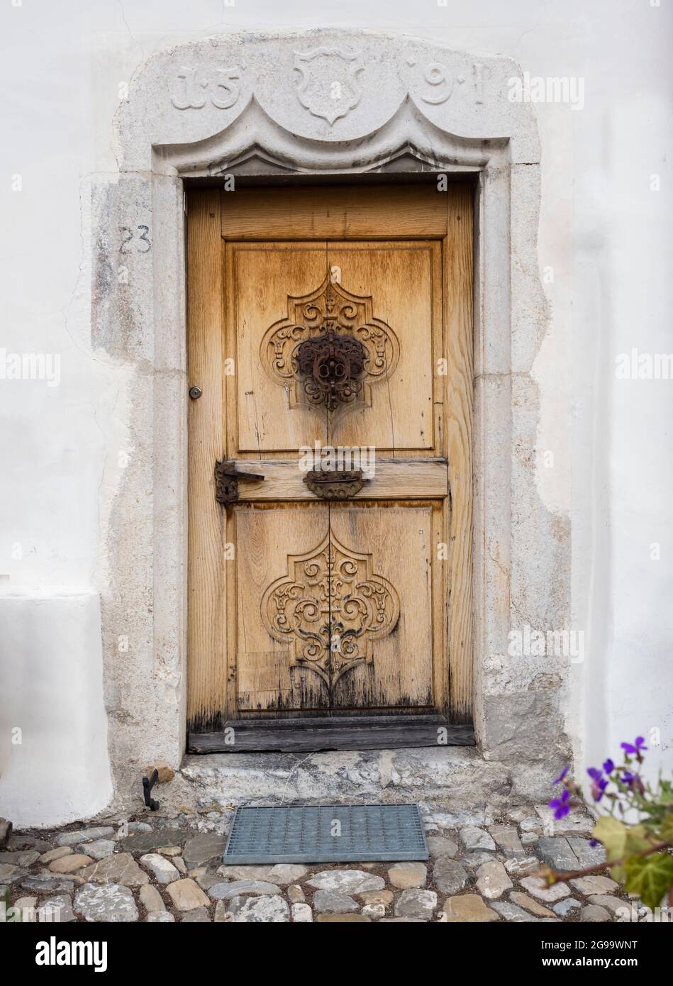 Porta ornata in legno e facciata di un tradizionale edificio svizzero nello storico villaggio svizzero Gruyere (Cantone di Friburgo) Foto Stock