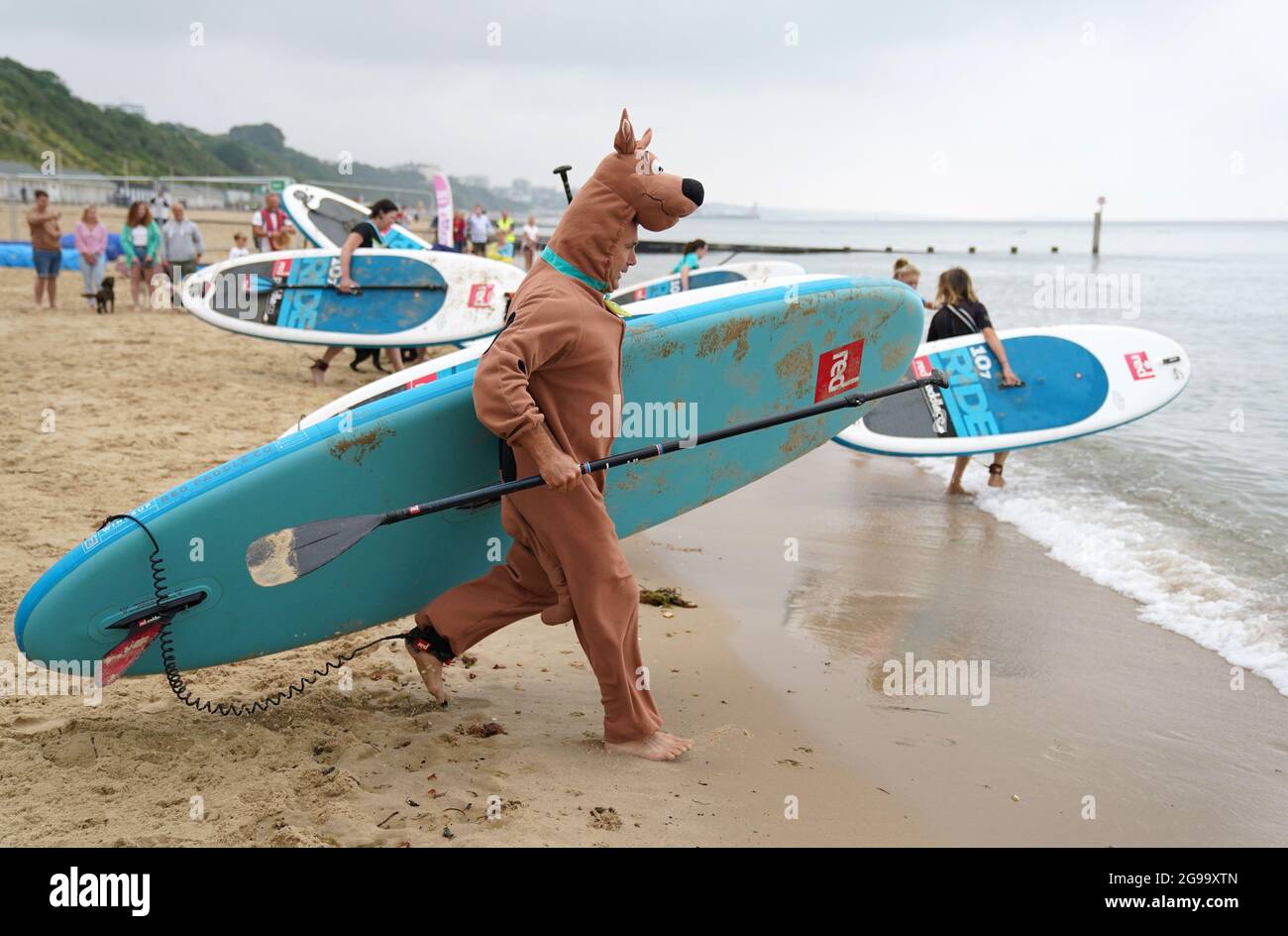 Simon Scammell partecipa a Dogmasters, l'unico campionato del paese per il surf con i cani e il paddleboard, a Branksome Beach a Poole, Dorset. Data immagine: Domenica 25 luglio 2021. Foto Stock