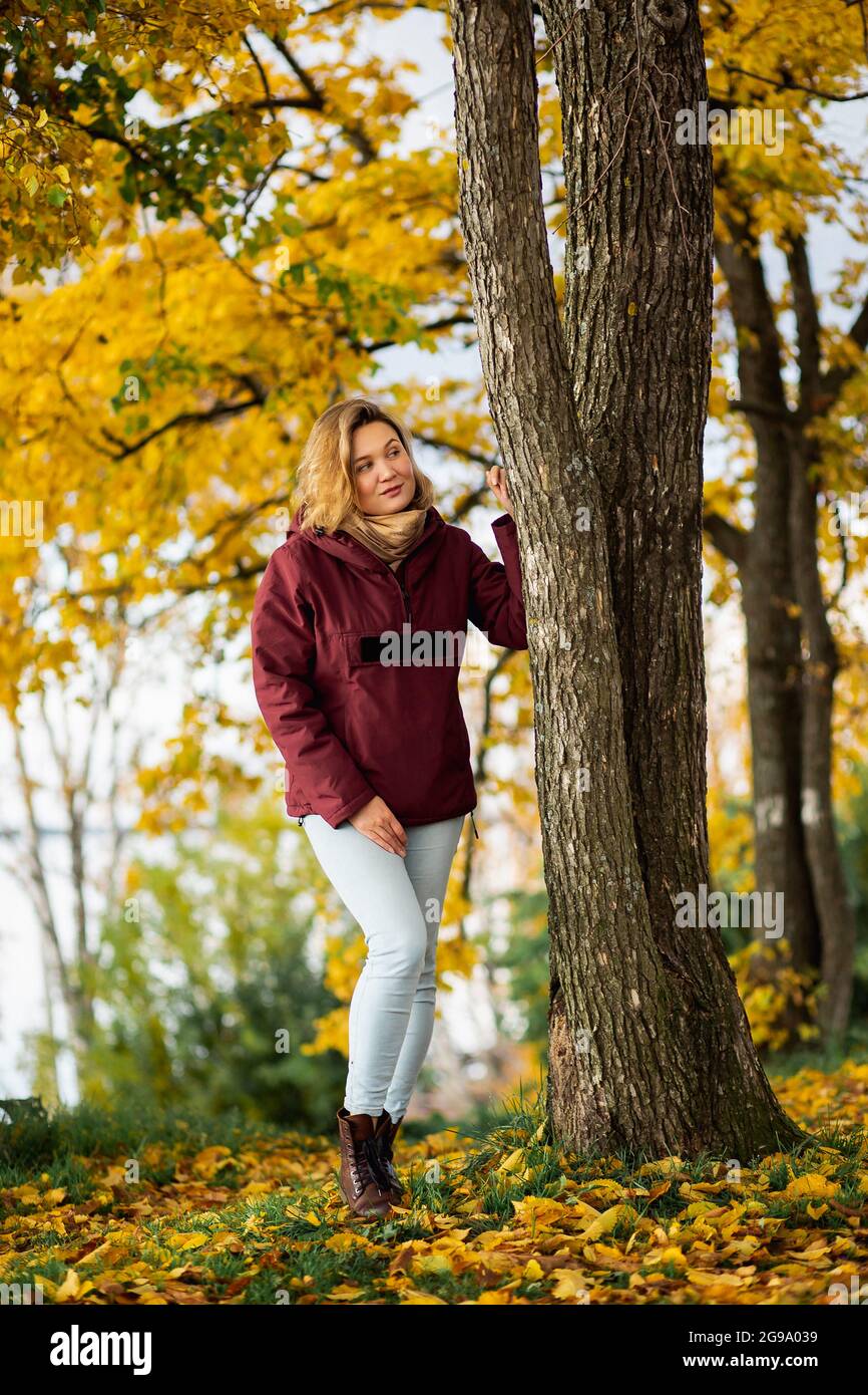 Persone, sentimenti, incontri stagionali concetto. Giocosa giovane donna che si gode le foglie gialle autunnali nel parco autunnale. Foto Stock