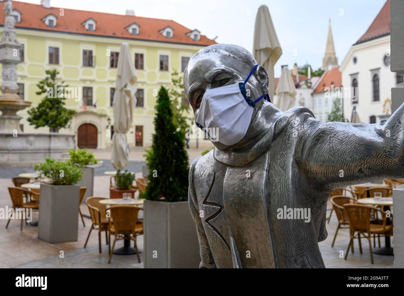 Statua di Schöne Náci con maschera facciale durante la pandemia del coronavirus. Foto Stock