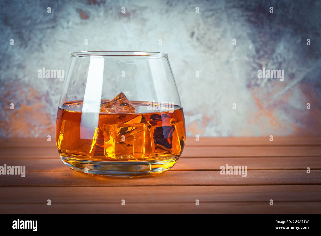 Bicchiere di whisky con ghiaccio. Vita morta. Brandy, borbone su un tavolo di legno marrone. Bevanda alcolica forte. Rum, scotch. Spazio di copia per il testo Foto Stock