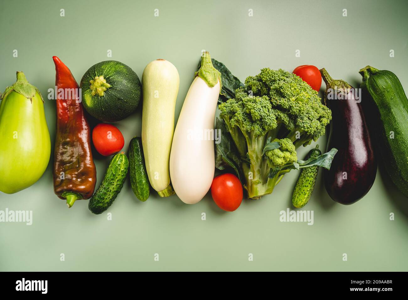 Verdure verdi biologiche eco-compatibili su sfondo verde. Disposizione piatta, vista dall'alto. Dieta sana e pulita e disintossicazione Foto Stock