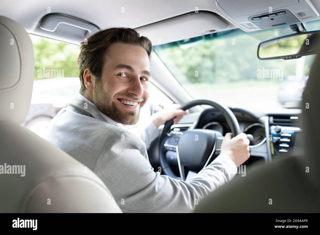 Lifestyle Travel turismo positività, trasporto. Un uomo di successo si siede al volante di un'auto prestigiosa Foto Stock