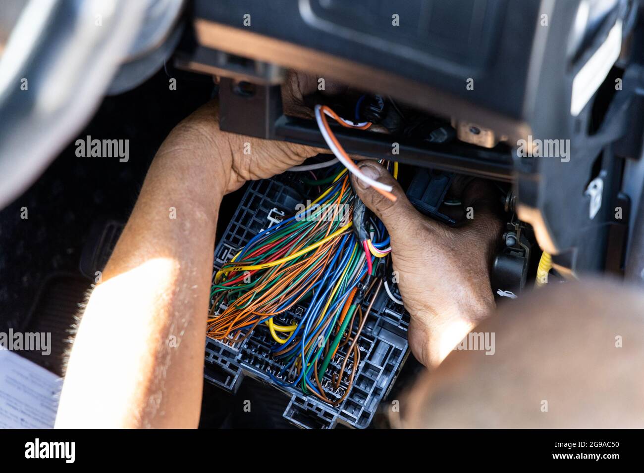Il tecnico automatico esegue la diagnosi e la risoluzione dei problemi di cablaggio della vettura Foto Stock