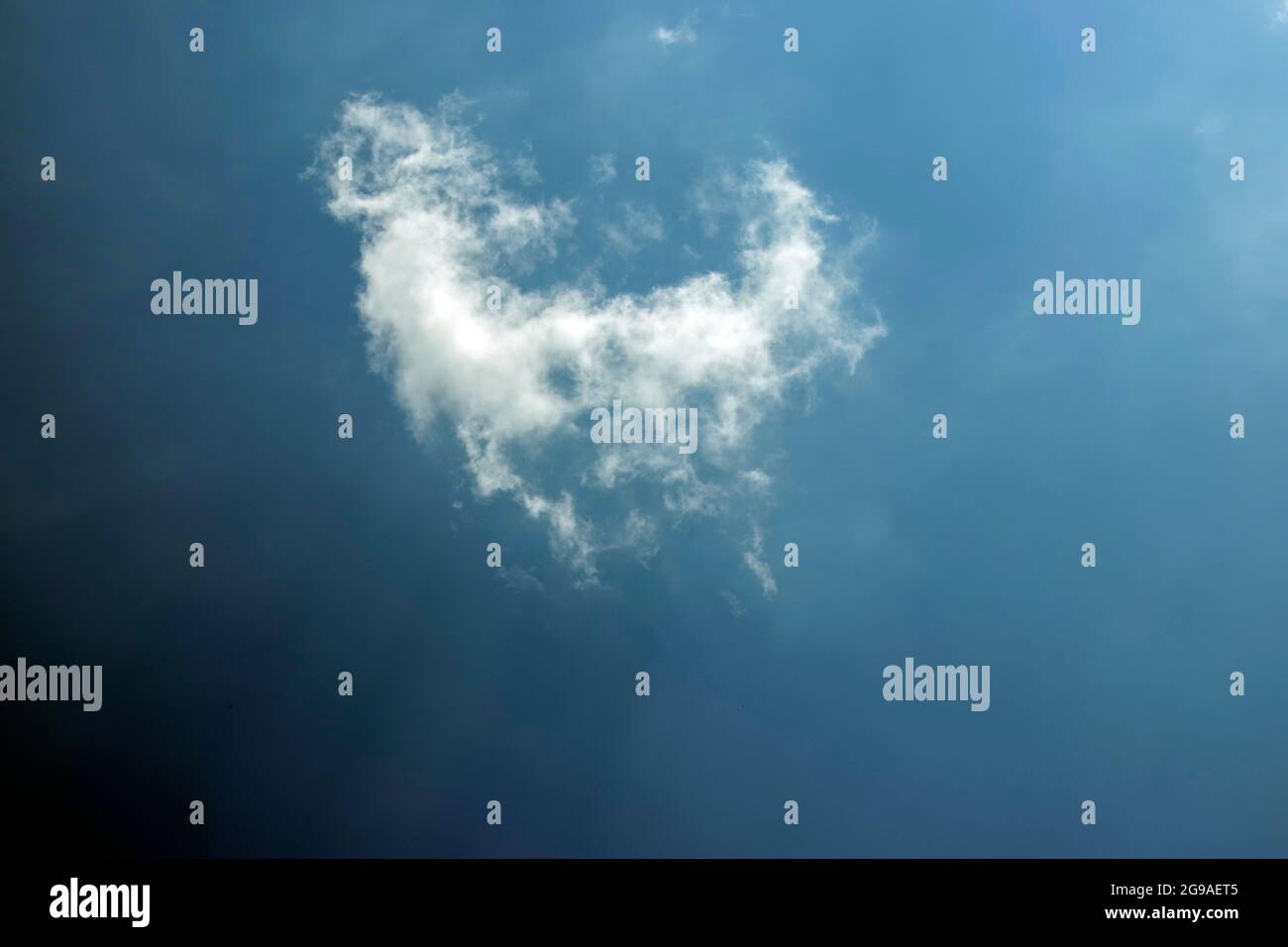 Un pezzo di nuvola bianca isolata o lacerata nel cielo blu scuro reale puro Foto Stock