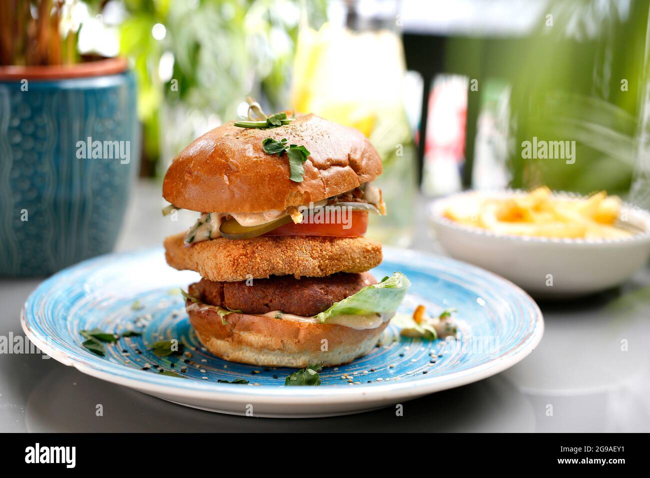 Hamburger vegetariano con formaggio tofu e verdure. Un piatto colorato appetitoso. Fotografia culinaria, stile alimentare. Foto Stock