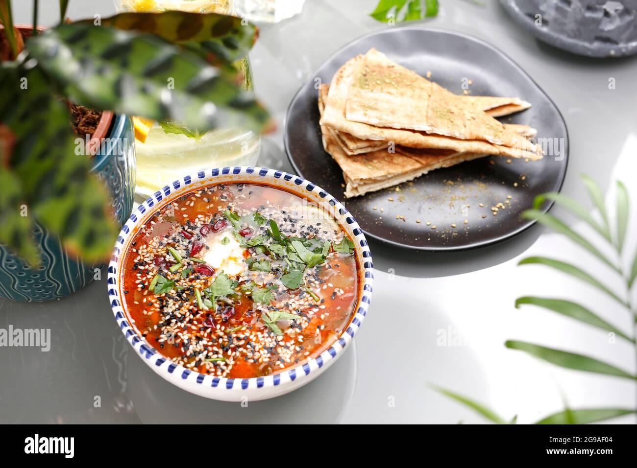 Zuppa di lenticchie con pomodori, panna acida ed erbe aromatiche. Piatti vegetariani, colorati e appetitosi. Foto Stock