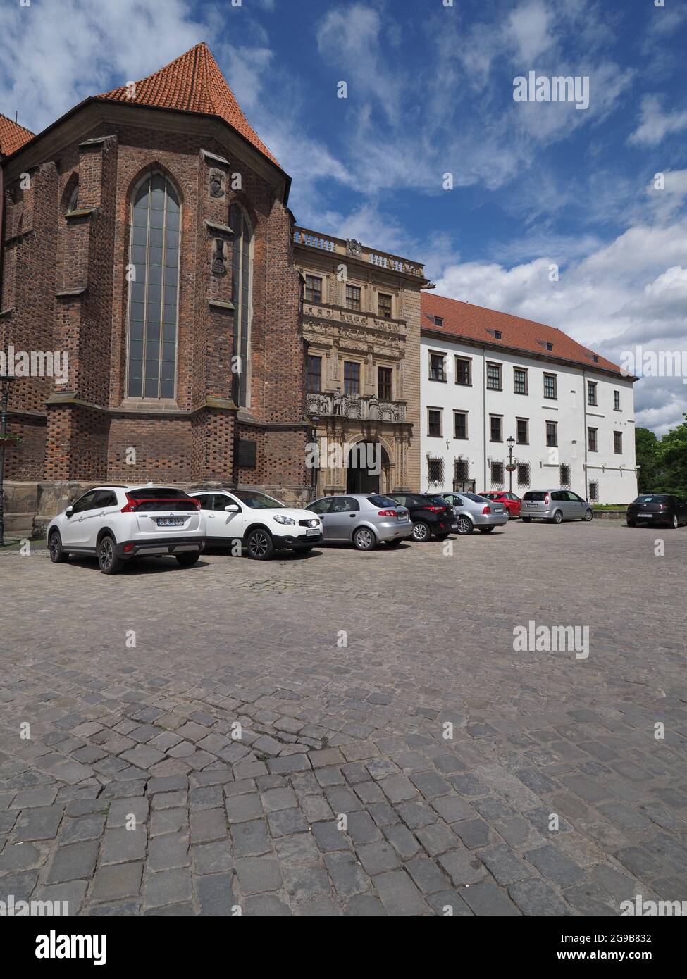 Castello di dinastia Piast e Chiesa di San Jadwiga nella città europea di Brzeg a Opole Voivodato, Polonia, cielo blu nel 2021 soleggiata primavera giorno su mai - verticale Foto Stock