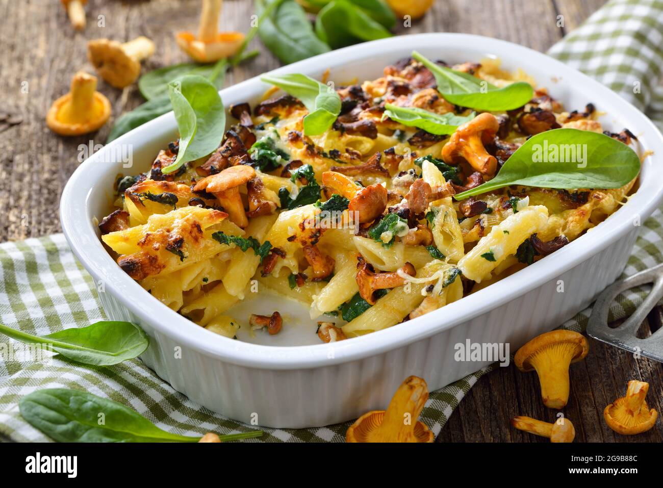 Casseruola di pasta chanterelle con foglie di spinaci e formaggio servito caldo dal forno Foto Stock