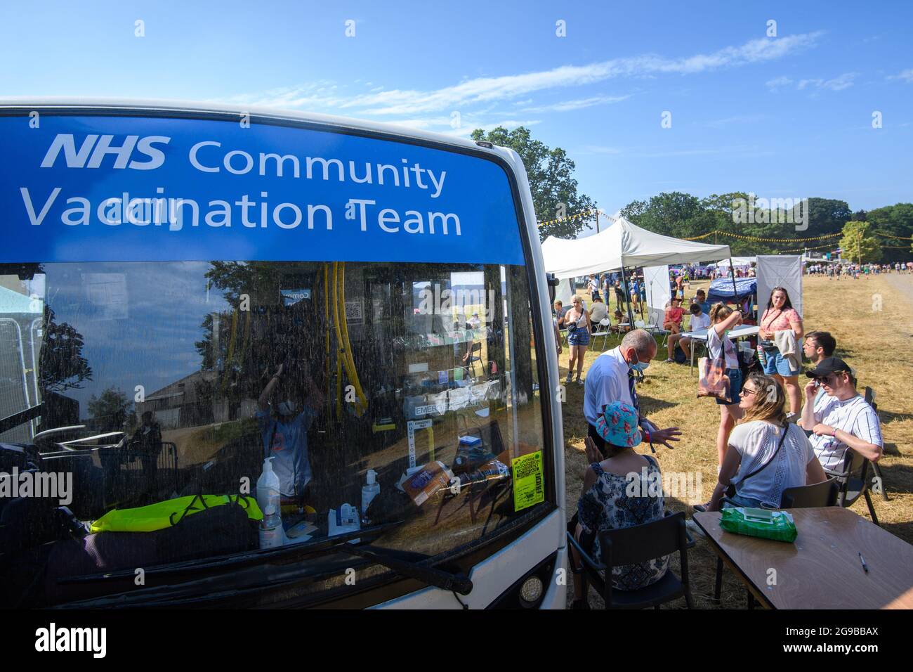 Southwold, Regno Unito. 25 luglio 2021. Coda dei festaioli per i vaccini Coronavirus, presso un autobus della squadra di vaccinazione della comunità NHS, il terzo giorno del festival Latitude a Henham Park, Southwold, Suffolk. Il servizio walk-in è una joint venture tra Norfolk e Waverley CCG e GM graham farmacie. Data immagine: Domenica 25 luglio 2021. Il credito fotografico dovrebbe essere: Matt Crossick/Empics/Alamy Live News Foto Stock